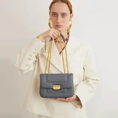 Stylish women's grey chain shoulder bag with gold hardware, perfect for fashion-forward outfits.