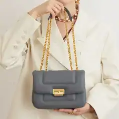 Stylish gray handbag with gold chain strap and hardware, perfect for fashion-forward women, made with high-quality materials, ideal for daily use and special occasions.