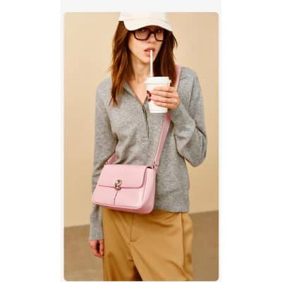 Fashionable woman with pink leather handbag, gray zip-up sweater, drinking coffee, casual style at Monalisa Medical Store.