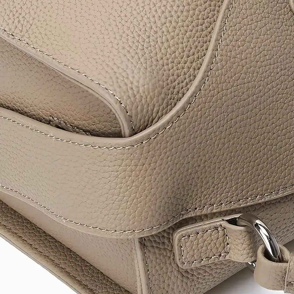 Close-up of a beige leather handbag showcasing textured material and high-quality craftsmanship, ideal for fashion accessories, luxury bags, and stylish handbags SEO purposes.
