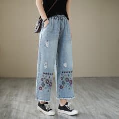 High-waisted distressed wide-leg jeans with colorful embroidery, casual streetwear style, perfect for fashion-forward outfits.