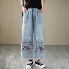 Stylish wide-leg jeans with colorful embroidery and distressed details, perfect for a casual, trendy look. Comfortable and versatile, ideal for everyday wear.