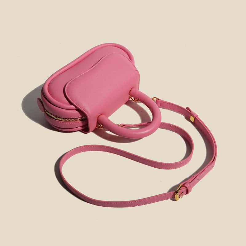 Stylish pink eye care accessory bag with handle and adjustable strap, perfect for storing glasses, contact lens supplies, or eye care essentials, combining fashion and functionality.