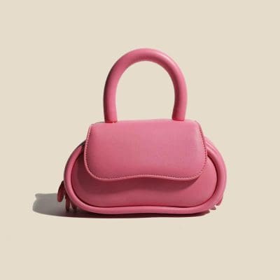 Cute pink handbag with rounded design, spacious for essentials, perfect for fashion-forward accessories lovers.