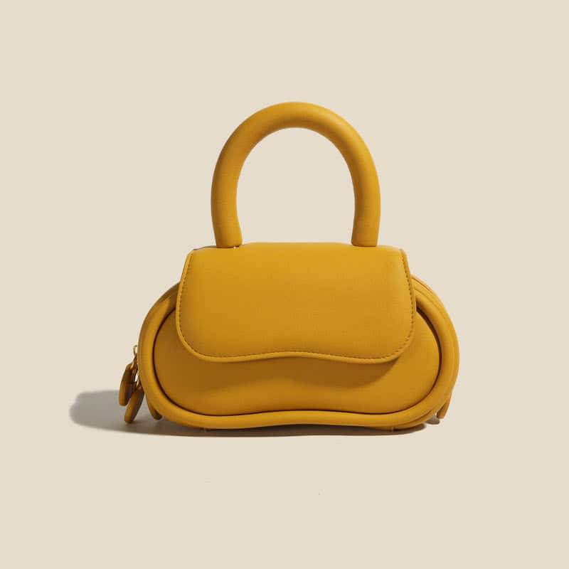 Stylish yellow handbag featuring a rounded design and top handle, ideal for fashion accessories and everyday use, showcasing modern fashion trends.