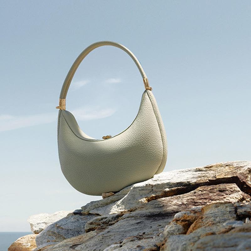 Stylish cream leather handbag for women, perfect for beach or casual outings. Designed with a comfortable strap and spacious interior. Ideal accessory for summer fashion and summer accessories.
