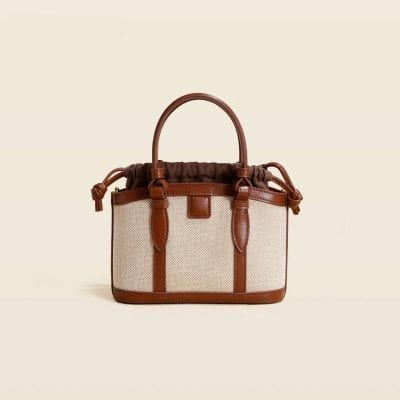 Elegant medium-sized handbag with leather accents, perfect for fashionable accessories and everyday use. Comes with durable handles and an adjustable drawstring for style and function.