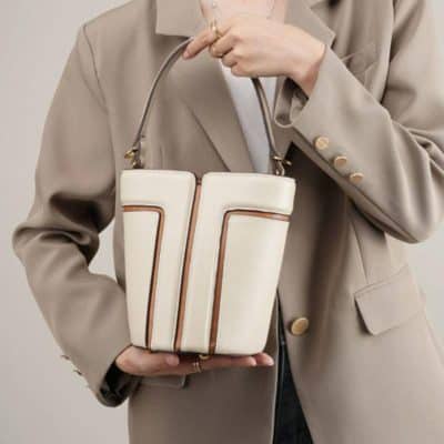 High-quality beige leather handbag with brown accents, perfect for fashion-forward individuals seeking luxury accessories. Classic design suitable for everyday use.