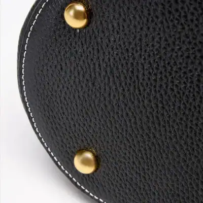 Close-up of a high-quality black leather handbag featuring gold-metal studs and white stitching, ideal for fashion and accessories shopping at Monalisa Store.
