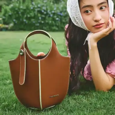 Elegant brown leather tote bag with modern design, perfect for everyday use and stylish accessories.
