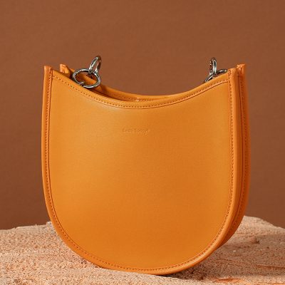 Stylish orange leather handbag with silver hardware, perfect for fashion-forward accessories. Compact design ideal for daily use and casual outings.