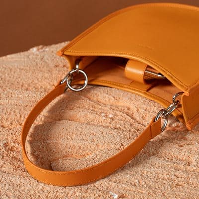 Stylish orange handbag with a sleek strap and spacious interior, perfect for everyday use and fashionable accessories.