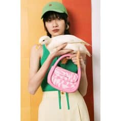 Stylish young woman with a duck, showcasing chic fashion accessories from Monalisa Store including a pink checkered handbag, ideal for fashion-forward and accessory enthusiasts.