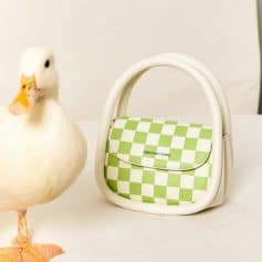 Stylish green and white checkerboard handbag with white handle, perfect for trendy fashion statements and everyday use.