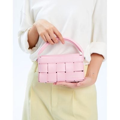 Pink designer handbag with woven strap detail, perfect for fashion-forward accessories. Ideal for casual or formal occasions, available at Monalisa Store.
