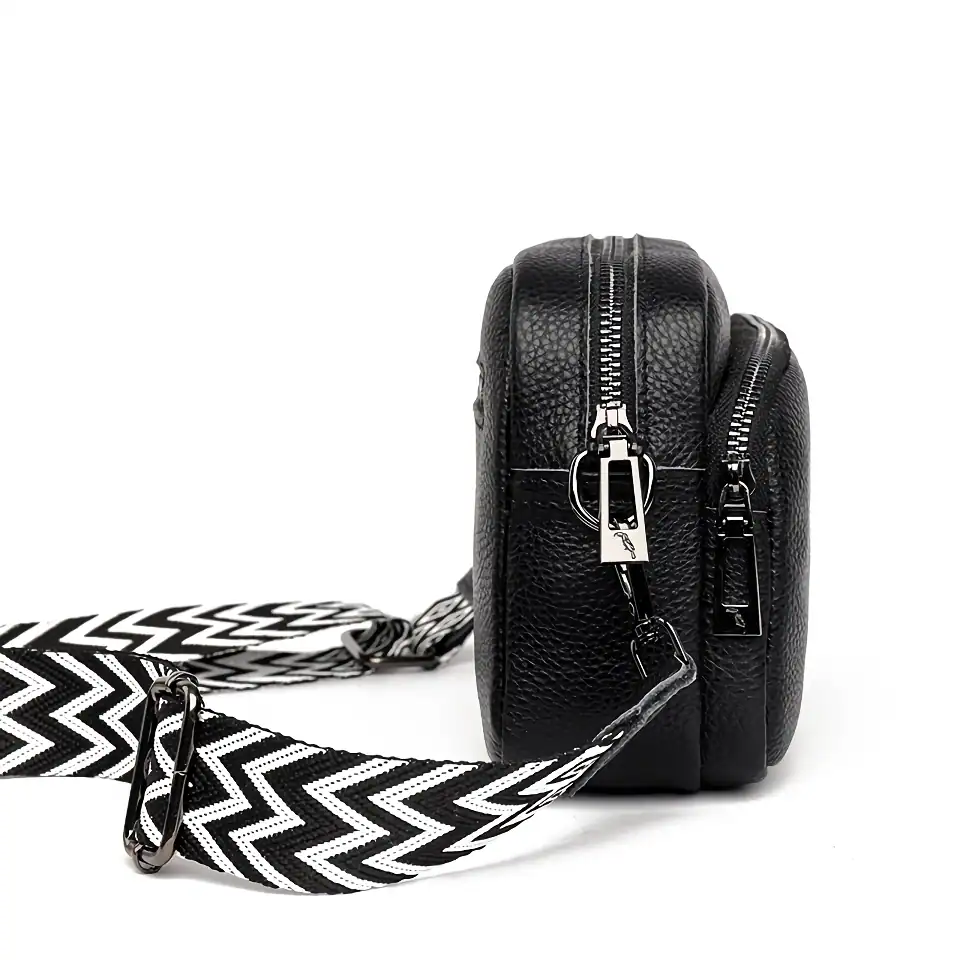 Durable black leather crossbody bag with multiple zippers, stylish black and white patterned strap, perfect for medical professionals or accessories lovers.