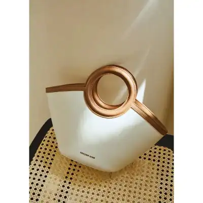 Luxurious white leather tote with a distinctive circular handle, perfect for stylish accessorizing and versatile carry. Features high-quality craftsmanship for fashion-conscious individuals.