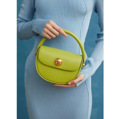 Bright green fashion handbag with a rounded design, featuring a gold twist lock closure and a sleek top handle, perfect for stylish accessories.