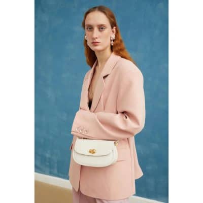 Beautiful woman wearing stylish sunglasses and designer handbags, showcasing trendy optical accessories and fashionable eyewear options available at Monalisa Store.