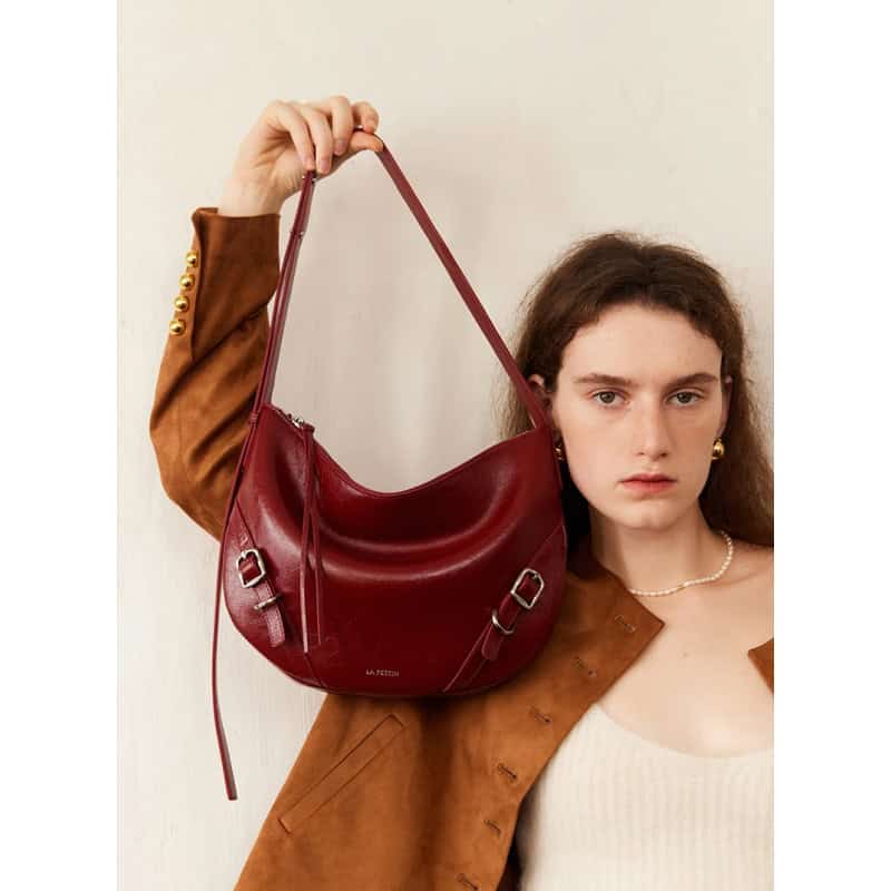 A stylish woman showcasing a red leather handbag from Monalisa Medical's exclusive collection, perfect for fashion-forward individuals seeking quality and elegance.