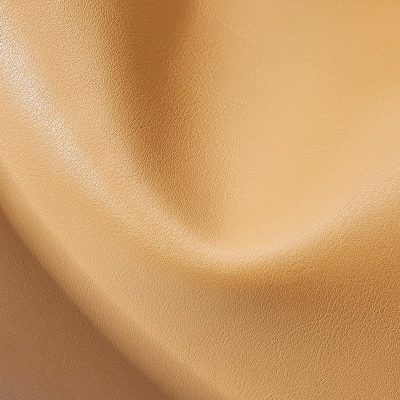 Close-up of premium golden optic fabric, ideal for sunglasses and eyewear accessories, showcasing superior quality, sleek finish, and elegant appeal for optical stores.