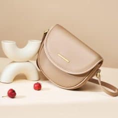 Elegant beige leather crossbody bag with minimalistic design, perfect for daily use and stylish outings. Features a gold accent and adjustable strap for comfort and versatility.