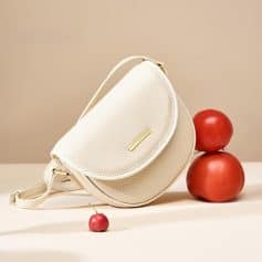 Stylish cream leather handbag with gold zipper detail, versatile accessory for everyday wear and special occasions.