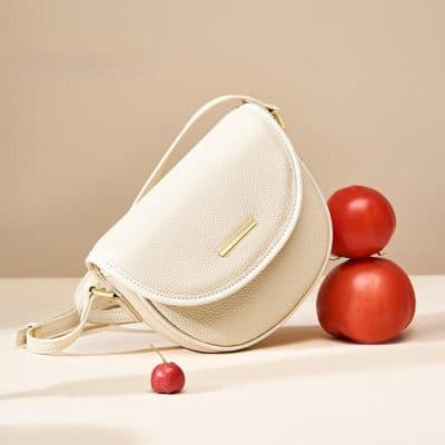 Stylish cream leather handbag with gold zipper detail, versatile accessory for everyday wear and special occasions.