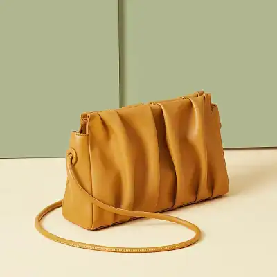 Stylish mustard leather handbag with unique pleated design, perfect for fashion-forward women seeking luxury and sophistication. Ideal for daily use or special occasions.