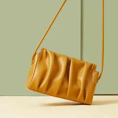 Elegant mustard yellow leather handbag with pleated design, perfect for fashion accessories and daily use. Stylish and versatile for any wardrobe.