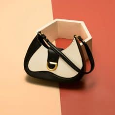 Elegant fashion handbag for women featuring black and white leather with gold accents, perfect for daily use or special occasions.