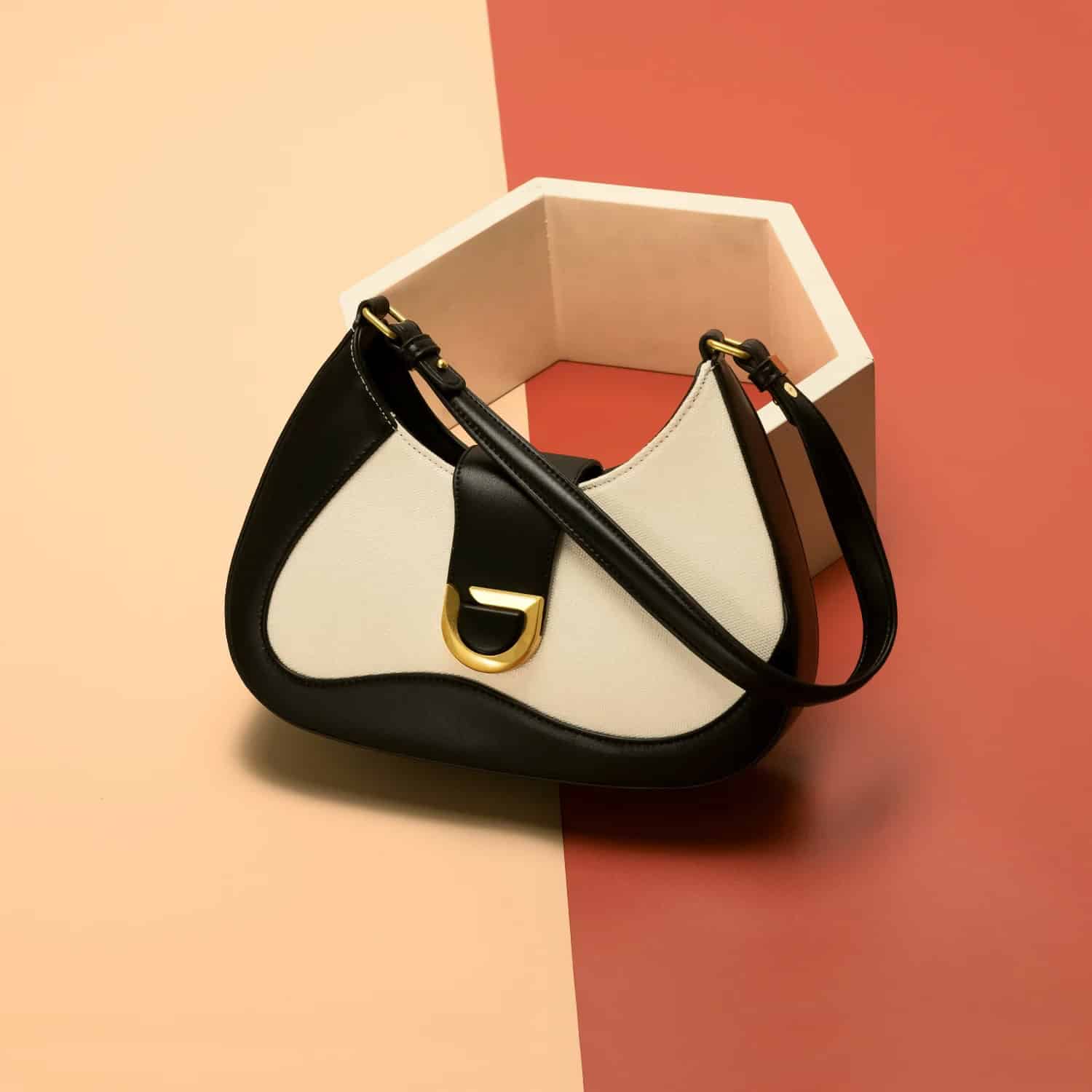 Elegant fashion handbag for women featuring black and white leather with gold accents, perfect for daily use or special occasions.