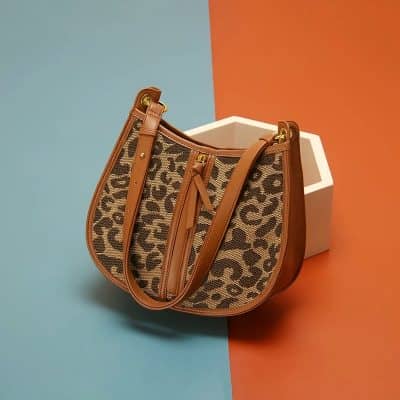 Stylish leopard print leather handbag with gold accents, perfect for fashion-forward women. Ideal for daily use or special occasions, combining elegance and functionality.