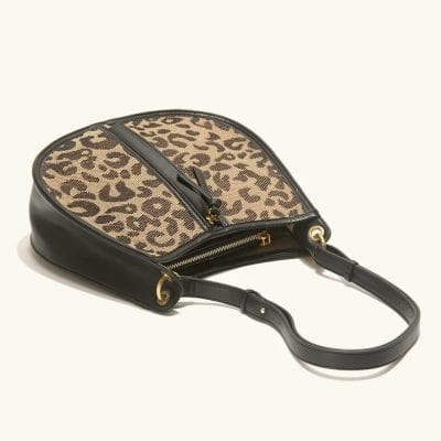 Leopard print stylish handbag with black leather accents, gold hardware, and convenient zipper closure, perfect for fashion-forward women.