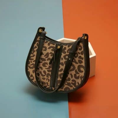 Stylish leopard print handbag with black leather accents, perfect for fashion-forward accessories. Elevate your look with this trendy bag from Monalisa Medical Store's opt collection.