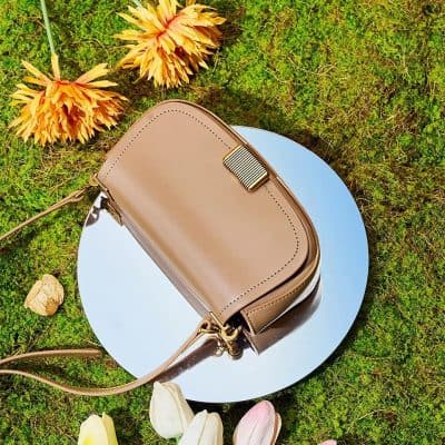 Stylish beige handbag perfect for fashion-forward women, featuring gold accents and a sleek design. Ideal for daily use or special occasions.