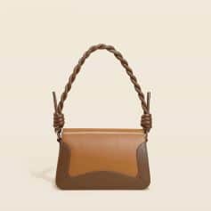 Stylish brown leather handbag with a twisted handle, perfect for fashion-forward women. Features a modern design ideal for daily use or special occasions.