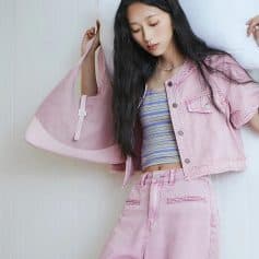 Young woman with trendy pink denim jacket and pants, holding a pink bag, at Monalisa Medical Optical store for fashionable eyewear and optical accessories.