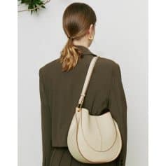 Minimalist cream-colored shoulder bag with gold accents for stylish eyewear storage.