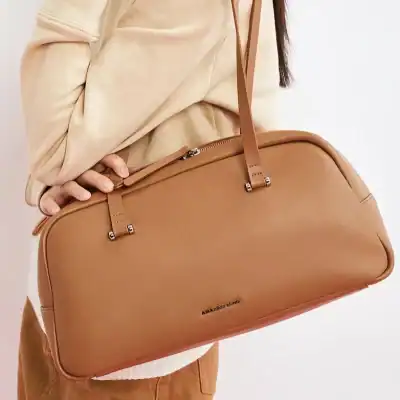 Stylish tan leather handbag with sturdy handles, perfect for travel and daily use, from Monalisa Medical.