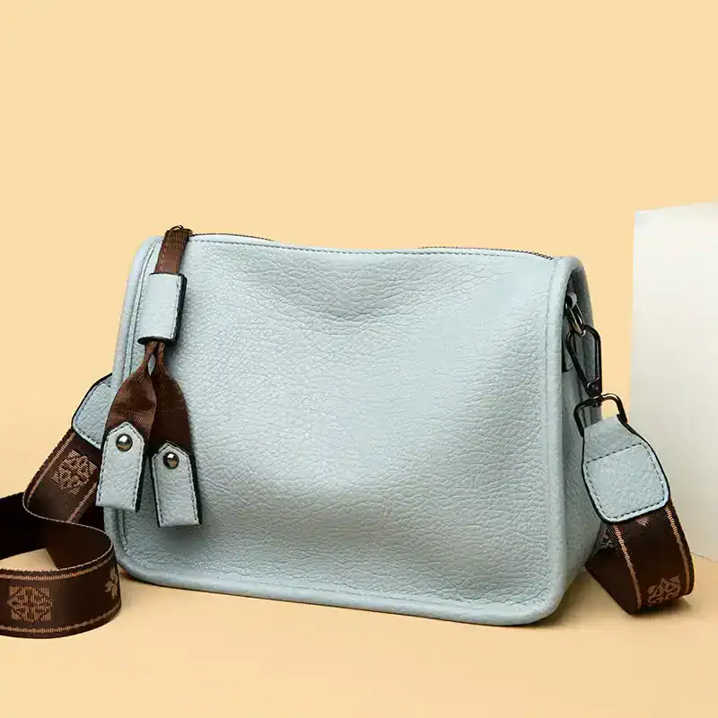 Elegant light blue leather bag with adjustable strap, perfect for fashion-forward women seeking luxury accessories. Durable material and stylish design for daily use.