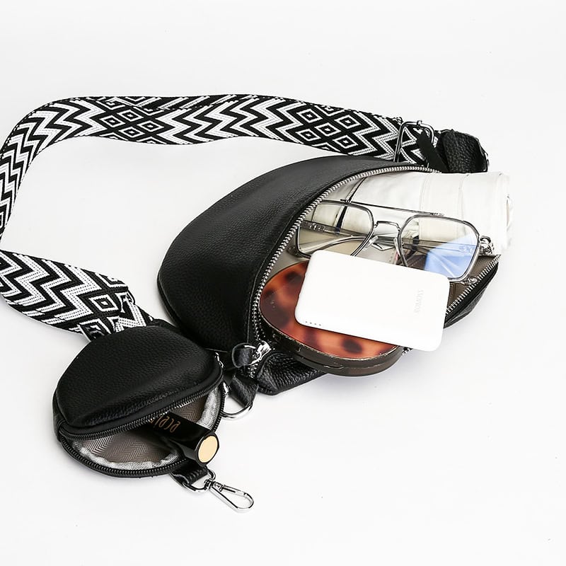 Stylish black crossbody bag with multiple compartments for storing glasses, sunglasses, and personal items, perfect for everyday use and travel.