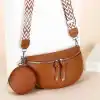 Fashionable brown leather crossbody bag with matching round pouch, ideal for stylish accessorizing and convenient storage. Perfect for everyday use.