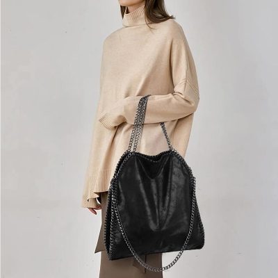 A trendy black leather tote bag with silver chain straps, perfect for fashion-forward women seeking functional accessories for daily use and stylish occasions.