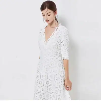 Stylish white eyelet dress with floral cutout design, perfect for summer or special occasions. Features 3/4 sleeves and V-neckline. Ideal for fashionable women seeking trendy, comfortable attire.