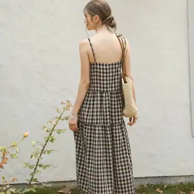 Elegant gingham maxi dress with spaghetti straps, perfect for summer wear or casual outings. Features a relaxed fit and stylish design. Ideal for women seeking comfortable yet chic fashion.