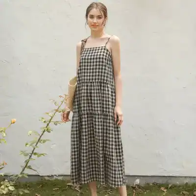 Stylish black and beige checkered maxi dress with spaghetti straps, perfect for warm weather and casual outings. Comfortable, trendy, and ideal for summer fashion.