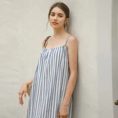 Elegant striped summer dress with thin shoulder straps, perfect for casual and resort wear, featuring comfortable fabric and a trendy design.