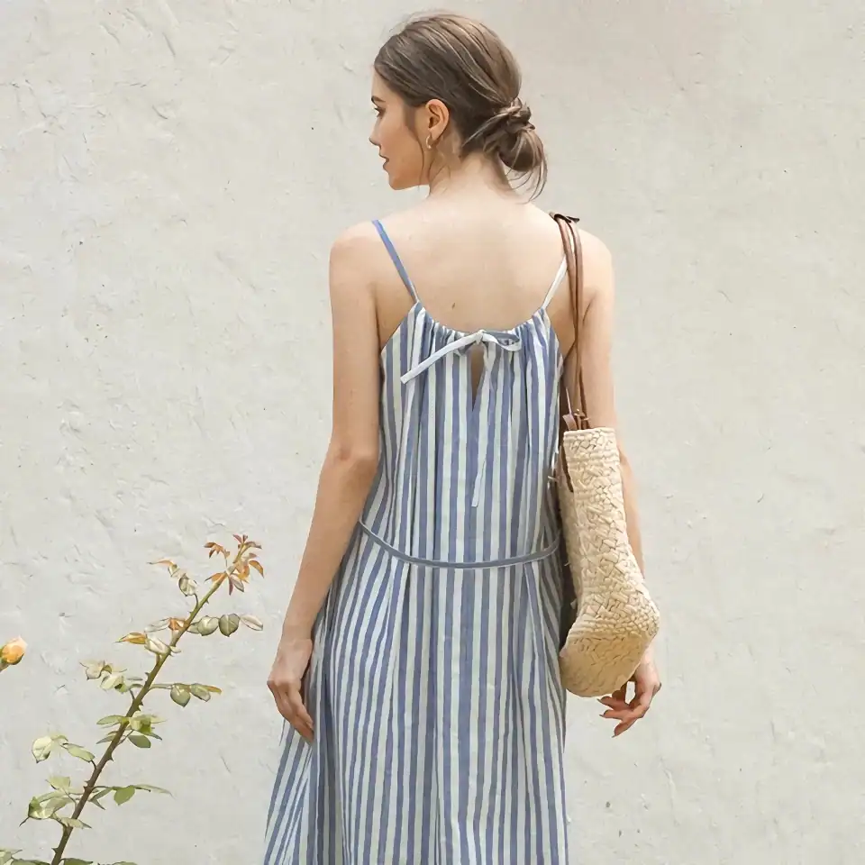 Comfortable blue and white striped summer dress with spaghetti straps and a back bow tie, perfect for casual and beachwear.