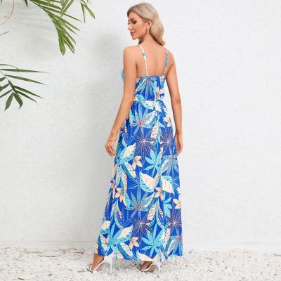 Bright blue maxi dress featuring a tropical leaf motif, adjustable spaghetti straps, and a flowy silhouette perfect for warm weather and beach vacations.